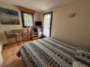 a bedroom with a bed and a table and window at Suite à 800m de la plage in Saint-Lunaire