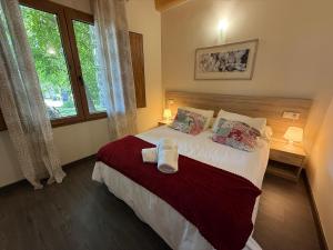 a bedroom with a bed with two pillows and a window at El Bulín de Prádena - Calle Real in Prádena del Rincón