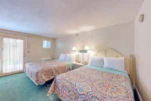 a hotel room with two beds and a window at Seafarer Resort-Unit 107 in Ogunquit +30 photos