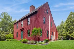 a red house with a tree in front of it at Beech Hill Lodge in Freeport