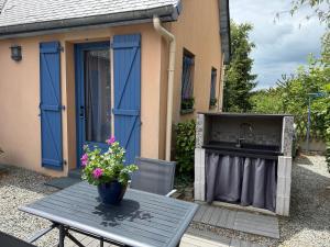 a patio table with a sink and a table with flowers at Suite à 800m de la plage in Saint-Lunaire