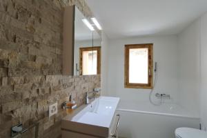 ein Badezimmer mit einem weißen Waschbecken und einer Ziegelwand in der Unterkunft Apartments Dimlej in St. Moritz
