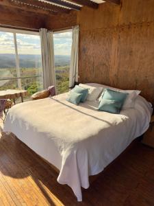 a large bed in a room with a large window at Eco-Suite Estación Penitente in Minas +22 photos