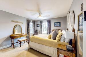 a bedroom with a bed and a table and a mirror at At Ease On Long Sands in York Beach