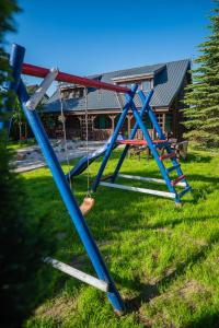 a group of swings in front of a house at DOMKI POD JARZĘBINĄ in Puck
