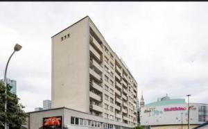 a tall white building with a sign on the side of it at Metro Central 3 Rooms Apartment in Warsaw