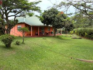 a house with a green yard with a yard at Masaka Backpackers, Tourists Cottage & Campsite in Masaka +14 photos