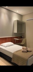 a bedroom with a bed and a tv on the wall at Pousada Bella in Vitória da Conquista