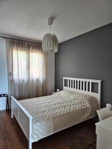 a bedroom with a white bed and a large window at Sutla House in Senkovec