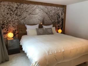 a bedroom with a large white bed with two lamps at Genuss in den Bergen! in Klosters Serneus