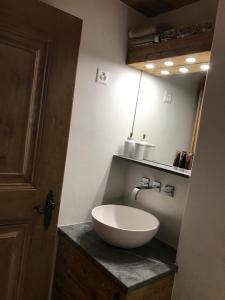 a bathroom with a white bowl sink on a counter at Genuss in den Bergen! in Klosters Serneus