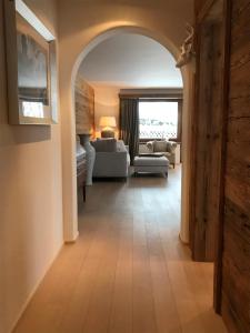 an archway leading to a living room with a couch at Genuss in den Bergen! in Klosters Serneus