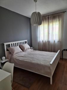 a bedroom with a white bed and a large window at Sutla House in Senkovec