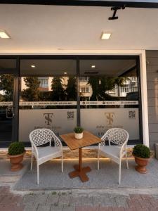 two chairs and a table in front of a building at Airport Suite Trabzon in Trabzon