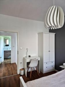 a bedroom with a desk and a bed and a white cabinet at Sutla House in Senkovec