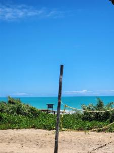 a net on a beach with the ocean in the background at Pousada Aldeia Do Mar - Caraíva BA in Caraíva +1 photo
