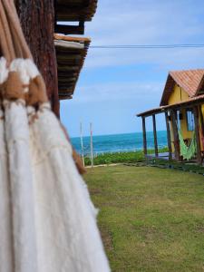 a house on the beach with the ocean in the background at Pousada Aldeia Do Mar - Caraíva BA in Caraíva