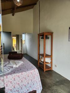 a bedroom with a bed and a wooden shelf at Pousada Aldeia Do Mar - Caraíva BA in Caraíva