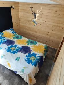a bedroom with a bed with a floral comforter at Powrót do Natury in Orzyny +6 photos