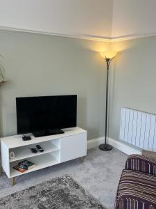 a living room with a white entertainment center with a flat screen tv at Stunning 2 bed apartment - central Norwich in Norwich