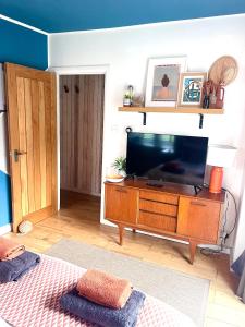 a living room with a flat screen tv on a dresser at St Ives Balcony Flat TreCar in St Ives