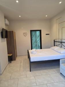 a bedroom with a large bed and a tv at Helgis Center in Himare +6 photos