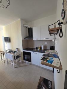a kitchen with white cabinets and a table in it at Monolocale 100metri dal mare in Fano