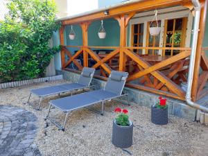 two chairs and a table in front of a house at Azúr Vendégház in Hajdúszoboszló