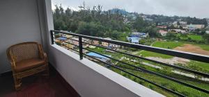 a balcony with a chair and a view of a city at hotel ruby international in Kodaikānāl
