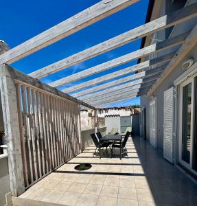 a deck with a table and chairs on a house at Apartment Garden breeze in Cres