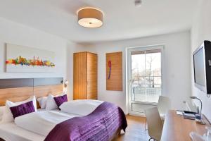 a bedroom with a bed and a desk and a window at Hotel Hecht Garni in Ingolstadt
