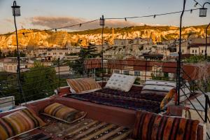 a couch on a balcony with a view of a city at Ayaz Stone House in Göreme