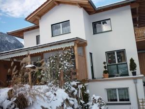 a house with snow on the ground at Ferienwohnung Salvenblick in Söll +18 photos