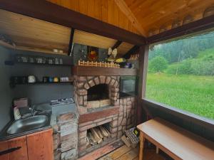 a kitchen with a stone fireplace in a tiny house at Карпатський затишок in Verkhovyna