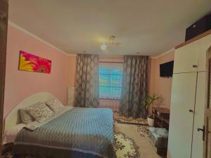 a bedroom with a bed and a window at Карпатський затишок in Verkhovyna