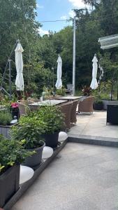 an outdoor patio with umbrellas and potted plants at Panorama House Opatija in Donji Rukavac