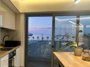 a kitchen with a sliding glass door with a view of a parking lot at 400 Steps Apartment with Sea View near Old Town in Rhodes Town +12 photos