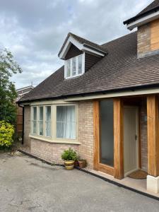 a brick house with a garage and a window at Quiet Annexe in Oundle in Oundle
