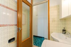 a bathroom with a toilet and a sink and a door at Anna Flat - 2 minuti dalla spiaggia in Lido di Jesolo +22 photos