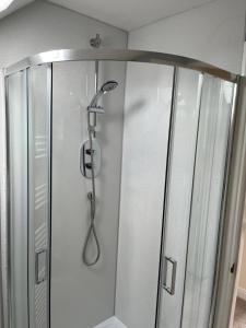 a shower with a shower head in a bathroom at Quiet Annexe in Oundle in Oundle