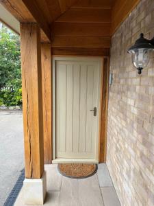 a front door of a house with a brick wall at Quiet Annexe in Oundle in Oundle