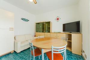 a dining room with a table and a tv at Anna Flat - 2 minuti dalla spiaggia in Lido di Jesolo
