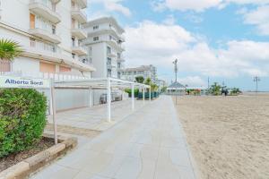 a walkway on the beach next to a building at Anna Flat - 2 minuti dalla spiaggia in Lido di Jesolo