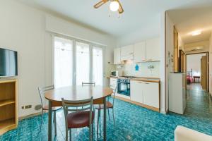a kitchen with a table and chairs in a room at Anna Flat - 2 minuti dalla spiaggia in Lido di Jesolo