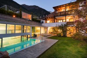 an exterior view of a house with a swimming pool at Landhaus Fux in Silandro