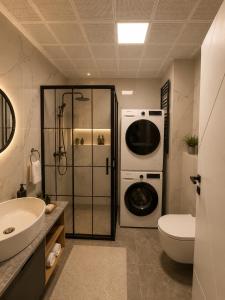 a bathroom with a washer and dryer and a sink at Mirşah Suit in Dalaman
