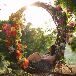 a woman sitting in a wicker basket filled with flowers at Abot Langit Calatagan in Calatagan