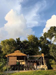 a building with a straw roof on top of a field at Abot Langit Calatagan in Calatagan