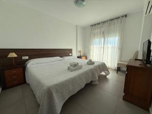 a bedroom with a bed with two towels on it at Living one Bed and Breakfast in Peniscola