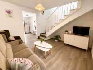 a living room with a couch and a tv at CASA EN EL CENTRO HISTORICO in Nerja